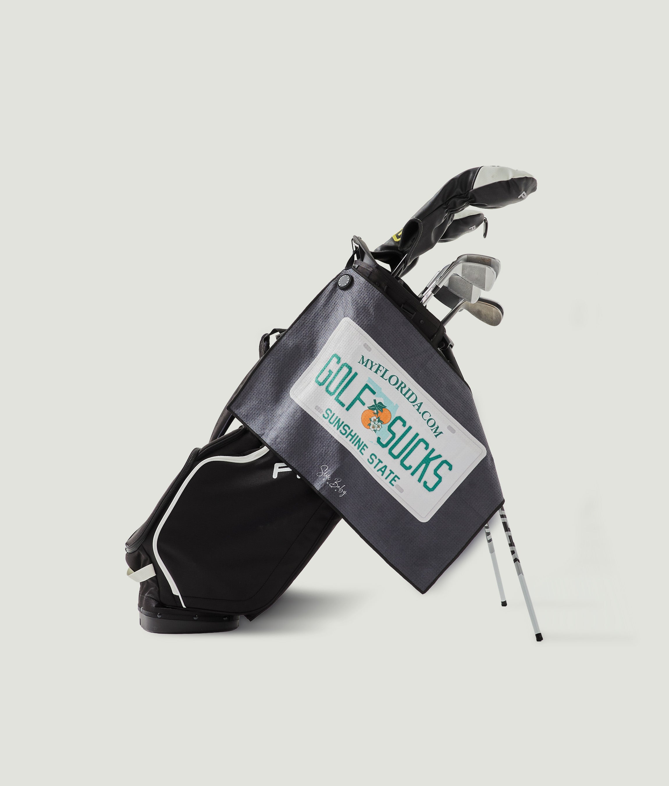 Golf bag with golf clubs on a light gray background