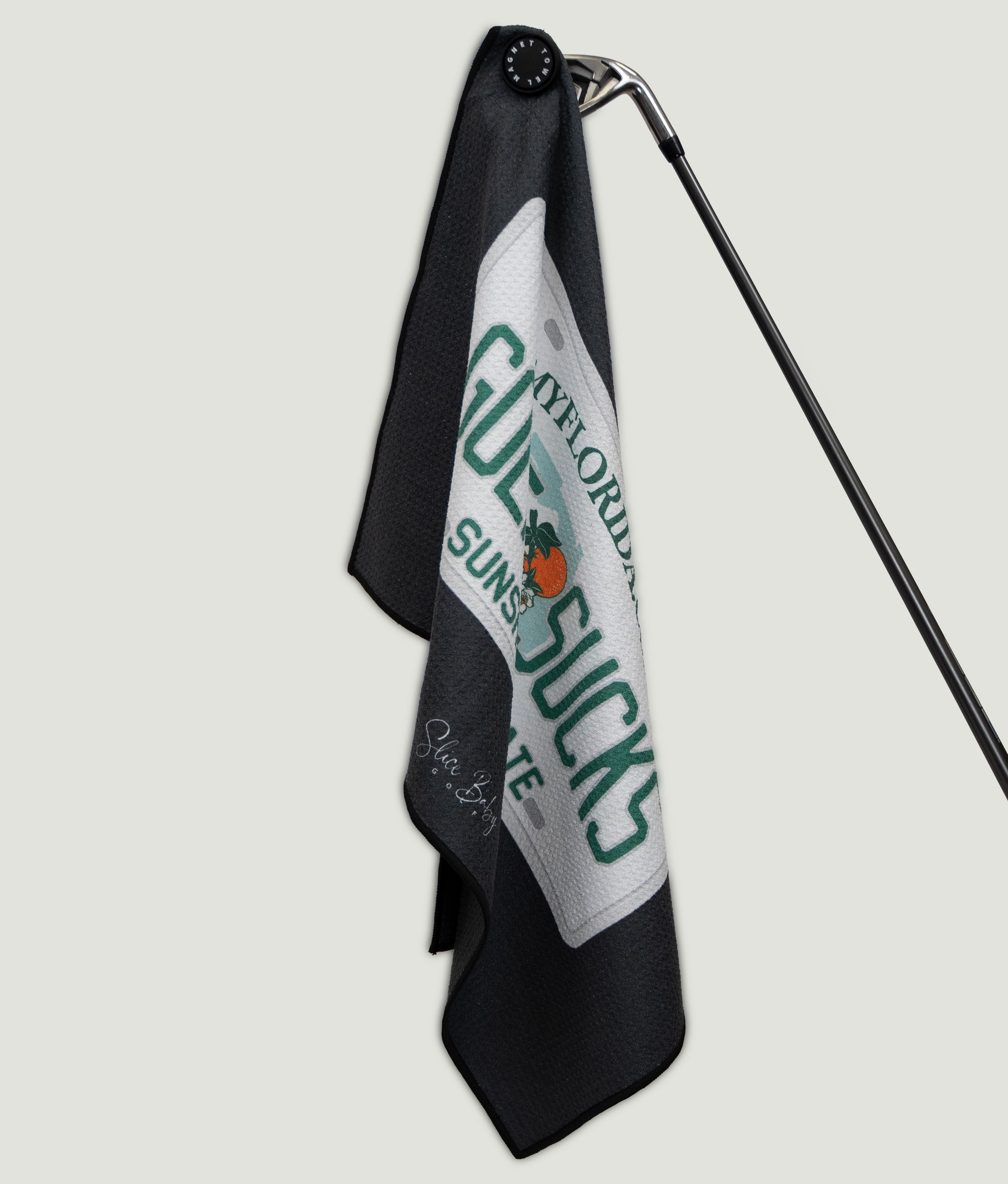 Golf towel with text and logo on a stand against a light gray background